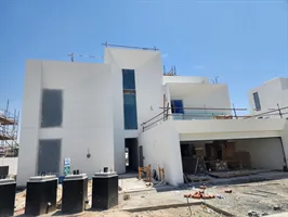 White rendered villas at Palmiera 3, The Oasis, with glazing in and materials still on site