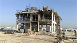 A concrete frame rising from cleared desert at Address Villas Tierra, The Oasis