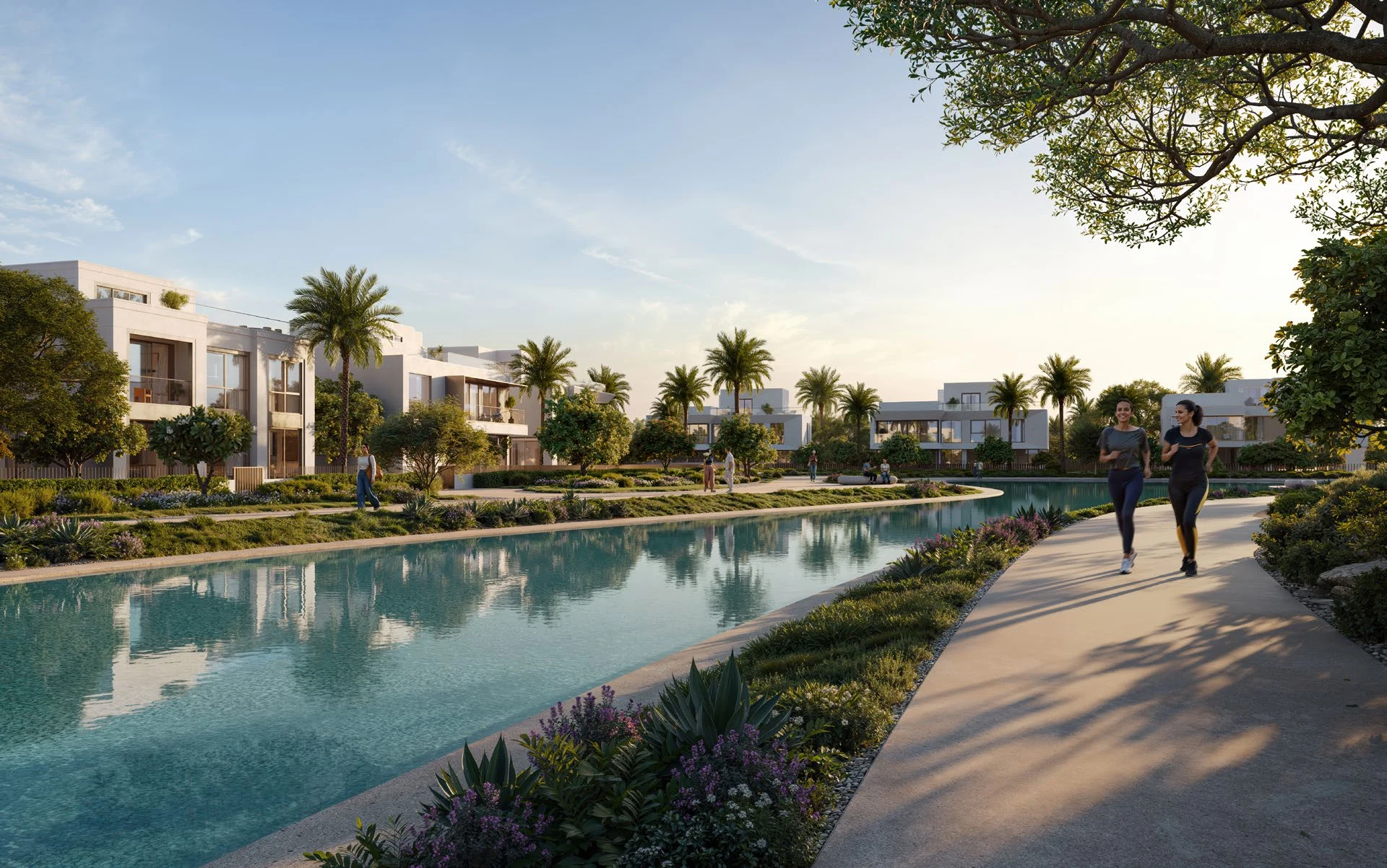 A swimmable lagoon at The Oasis by Emaar, with villas, palms and a walking path along the water